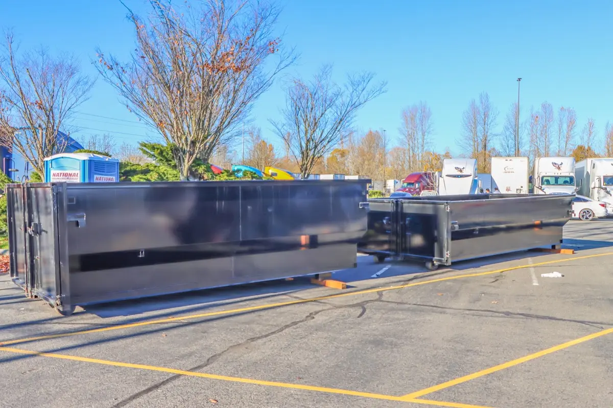 Professional dumpster rental service with roll-off container on residential driveway in PiÃ±on Hills